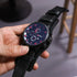 Black leather strap wristwatch with red dial accents and sporty, modern design