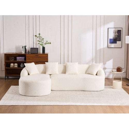 Modern living room with cream boucle curved sofa, cushioned seats, and neutral decor