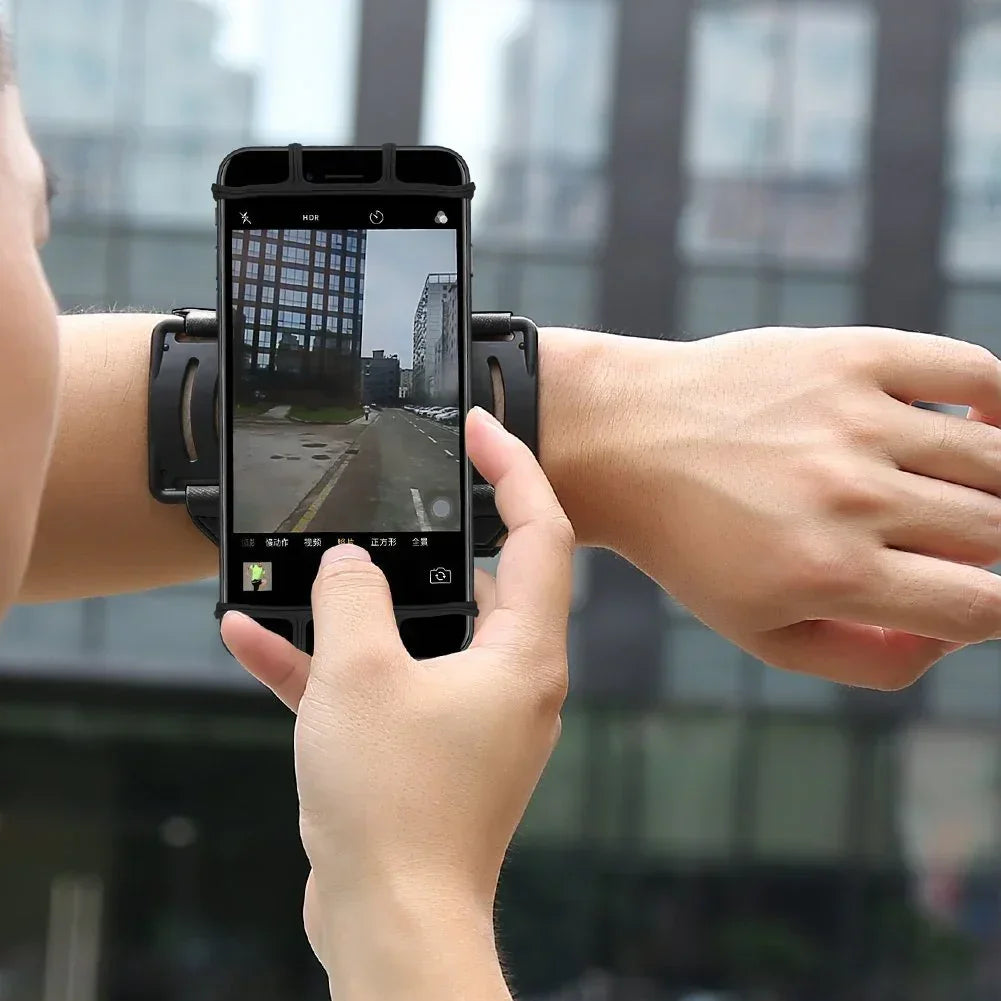 Black smartphone armband, adjustable fit, worn on forearm, street setting