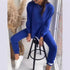 Woman wearing royal blue oversized sweatshirt and jogger pants set, relaxed fit, white sneakers