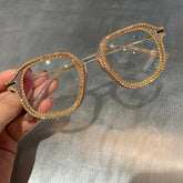 Gold-accented square eyeglasses with rhinestone trim, clear lenses, and oversized fit