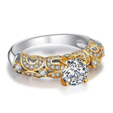 Gold and silver ring with intricate scrollwork and sparkling round-cut diamond center