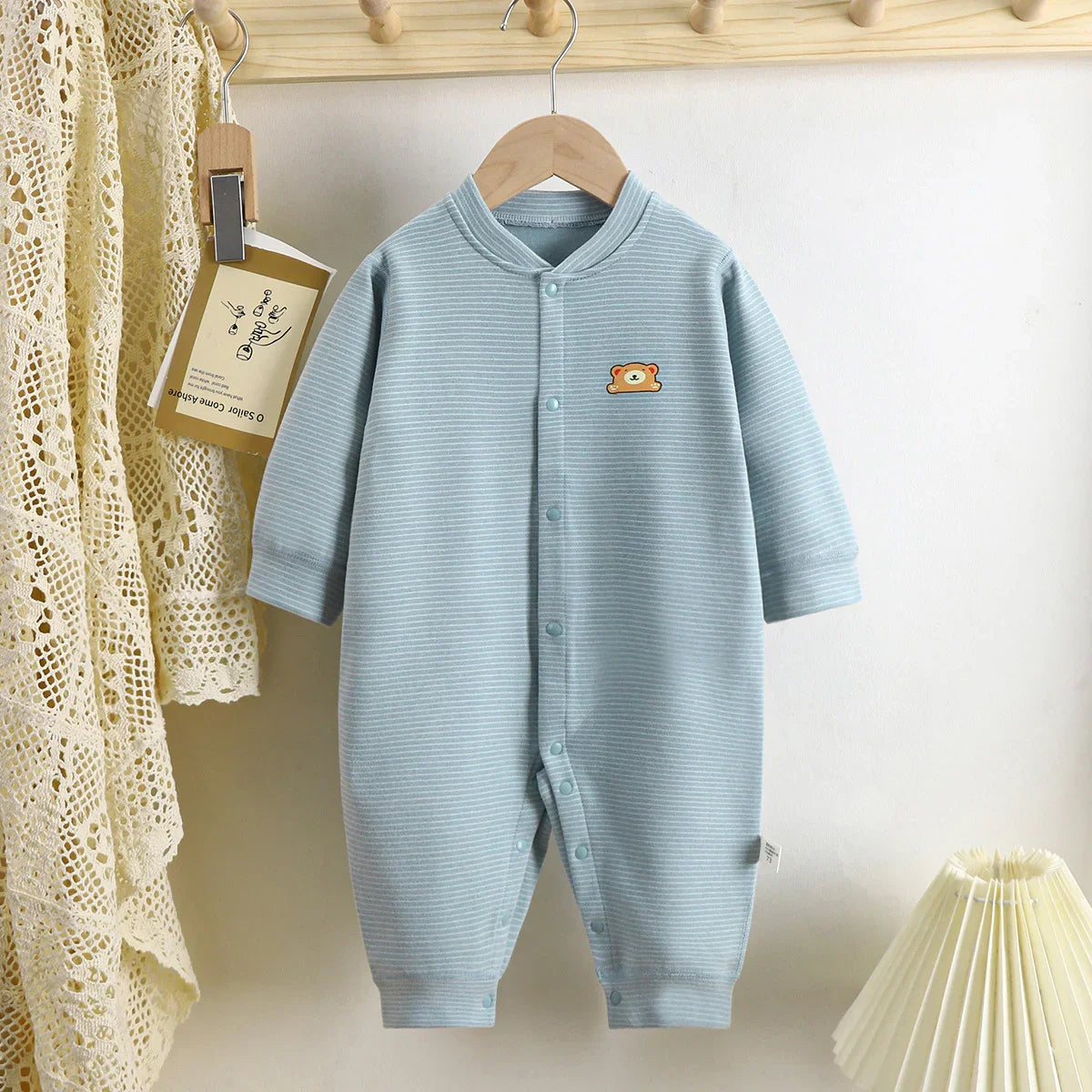 Light blue striped baby romper with long sleeves and bear patch, cotton material, relaxed fit