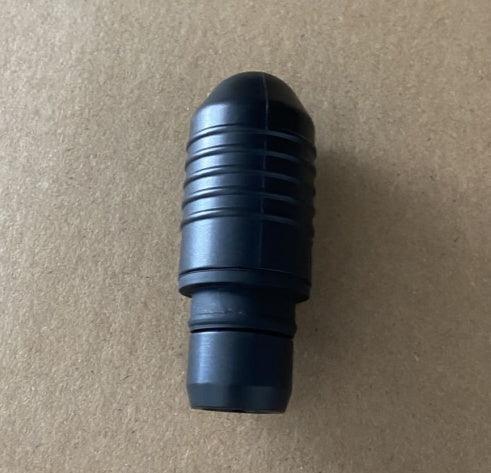 Black ribbed plastic connector piece on a plain brown background