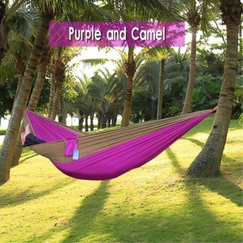 Two-tone purple and camel hammock, lightweight fabric, outdoor setting between palm trees