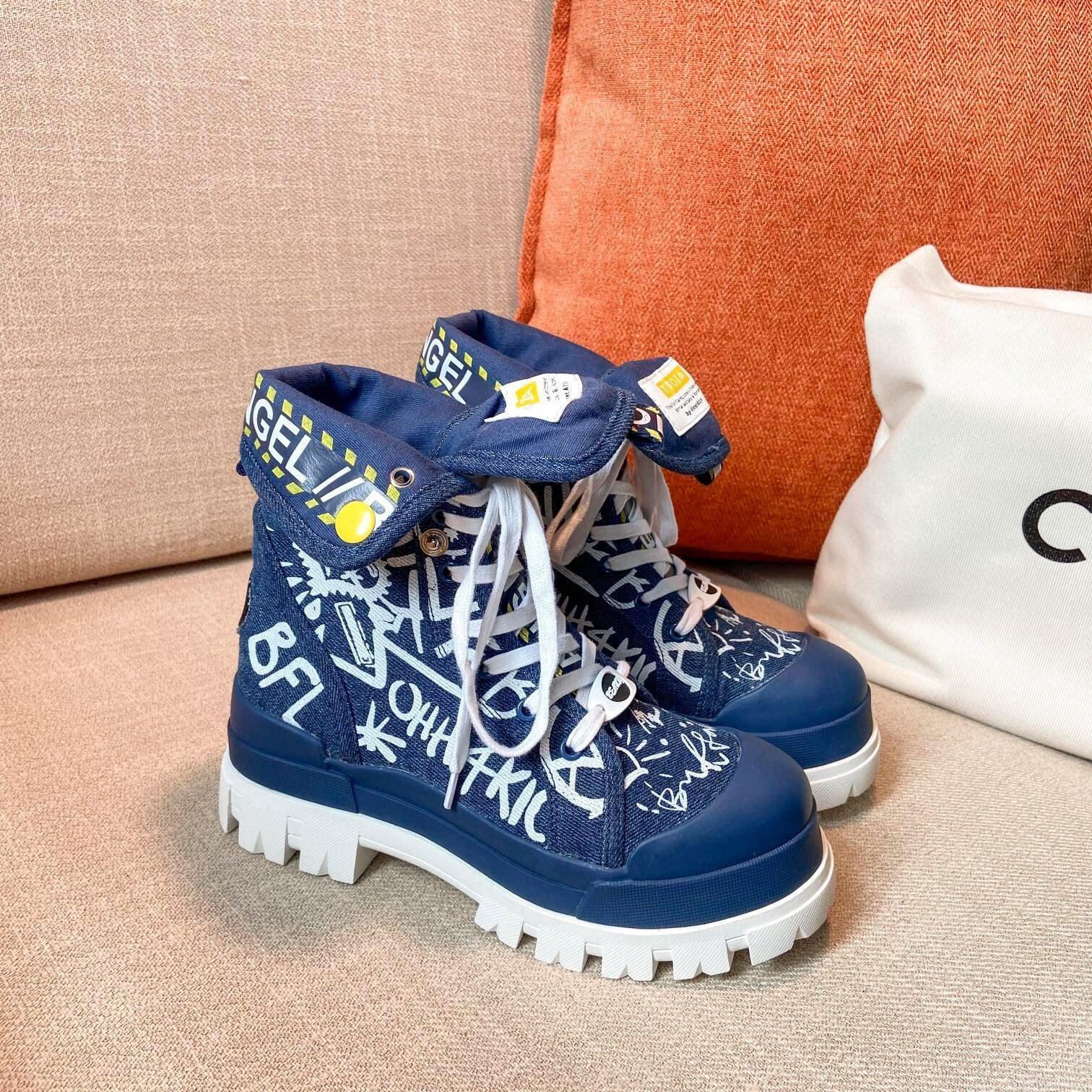 Blue canvas high-top sneakers with graffiti print, chunky white soles, and white laces