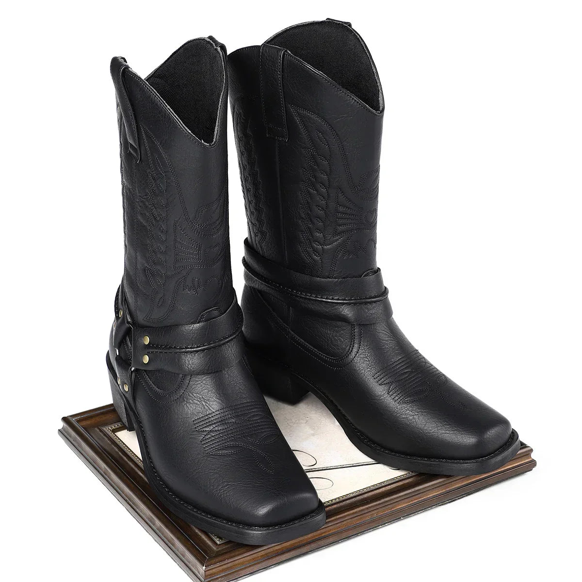Black faux leather cowboy boots with decorative stitching and harness detail, mid-calf fit.