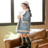 Girl in a light blue faux shearling coat with white trim, wearing a beret and winter boots
