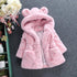 Pink faux fur hooded coat with bear ears, plush texture, relaxed fit, and front pockets