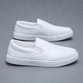 White slip-on sneakers with smooth faux leather upper and minimalist streetwear style