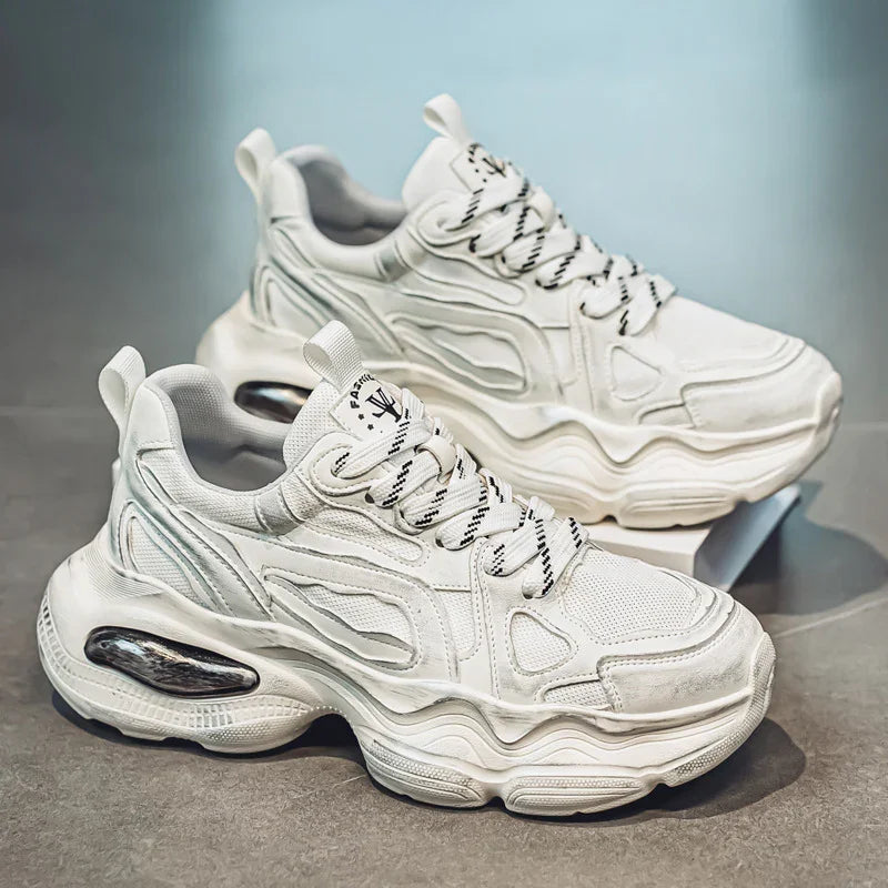 Chunky white mesh and leather sneakers with thick soles and black-accent laces on display.