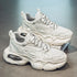 Chunky white mesh and leather sneakers with thick soles and black-accent laces on display.