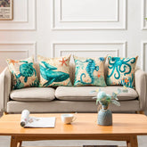 Beige linen sofa with ocean-themed throw pillows featuring teal marine animals and starfish