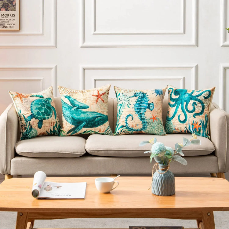Beige linen sofa with ocean-themed throw pillows featuring teal marine animals and starfish