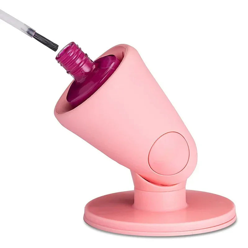 Pink silicone nail polish holder with a bottle of magenta nail polish inserted