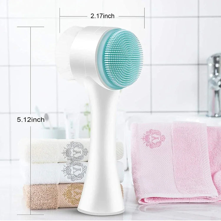 White and turquoise silicone facial cleansing brush with ergonomic handle, shown in bathroom setting.