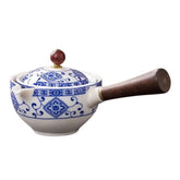 Ceramic pot with blue floral patterns, wooden handle, and a round lid knob