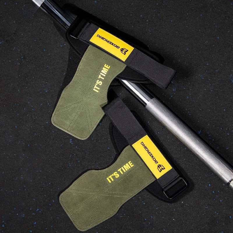 Olive green suede lifting straps with black and yellow accents, adjustable fit, on gym floor.