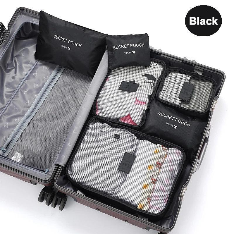 Black mesh packing cubes with neatly folded casual clothing in a suitcase, travel organizer set