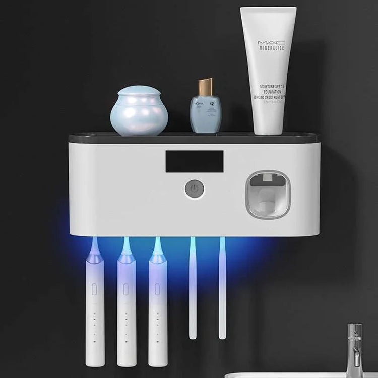 Wall-mounted white toothbrush holder with UV sterilizer, holding electric toothbrushes and toothpaste.