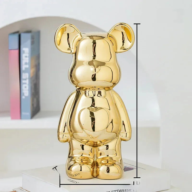 Shiny gold bear figurine with glossy metallic finish, placed on stacked books in modern decor.