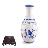 Blue and white porcelain style puzzle vase with floral patterns and black display stand