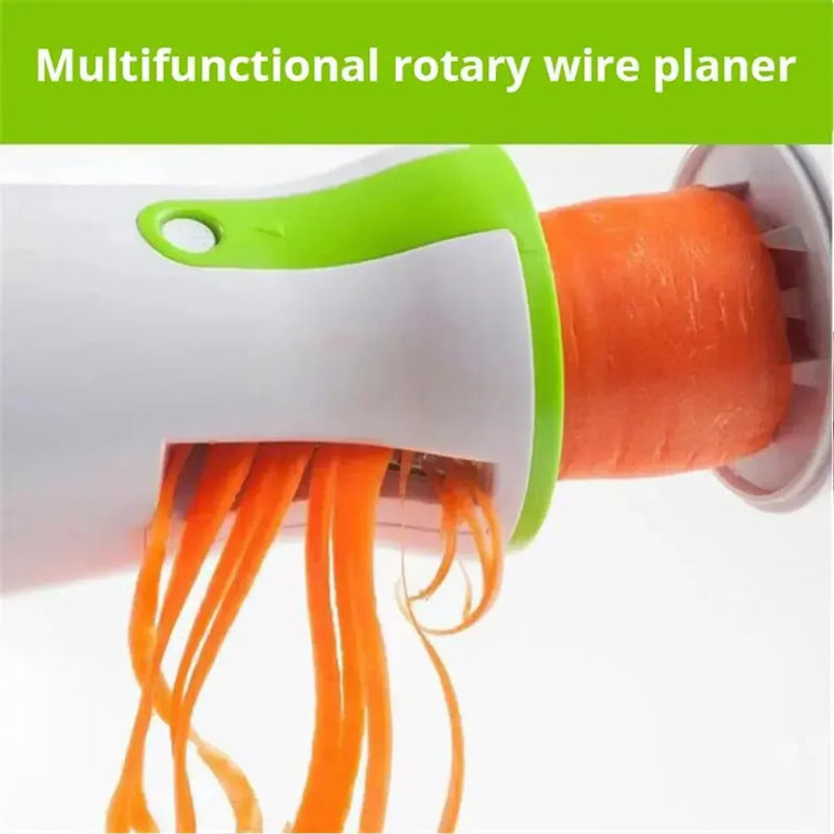Handheld rotary vegetable spiralizer shredding carrot, white and green plastic kitchen tool