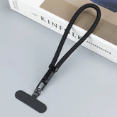 Black nylon phone lanyard with detachable clip and T-shaped attachment on a grey surface
