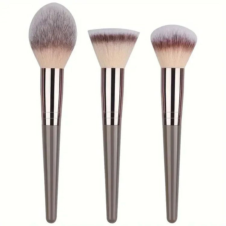 Set of three makeup brushes with soft bristles and metallic gray handles, modern design