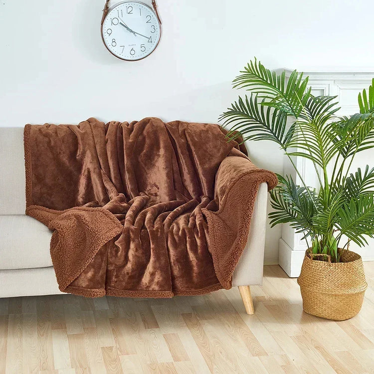 Soft brown fleece throw blanket draped over beige sofa, cozy living room decor