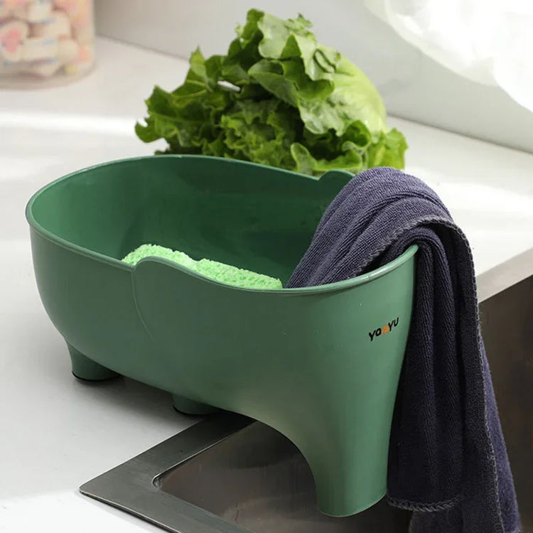Green plastic kitchen sink caddy with towels, modern countertop organization.