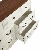 White wooden dresser with antique brass handles, brown top, and open drawers