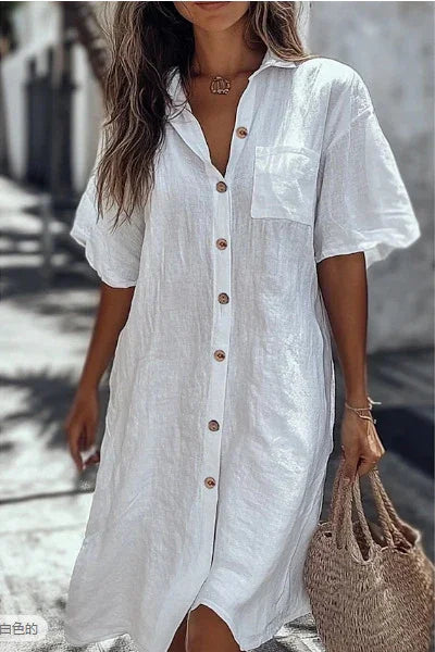 Woman wearing loose fit white linen button-down shirt dress with short sleeves