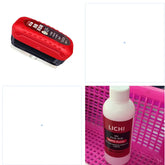 Red and black window cleaning tool and bottle of oil film remover in pink basket, closeup.