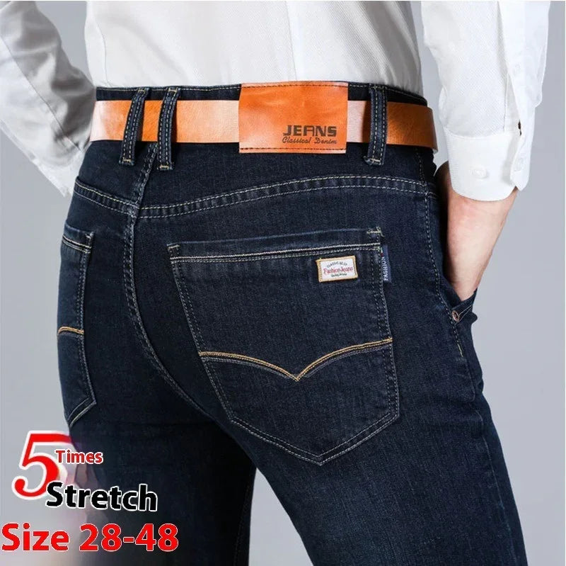 Dark blue stretch denim jeans with contrast stitching, slim fit, brown belt, rear pocket detail.