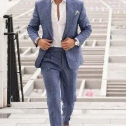 Man in tailored light blue suit with slim fit, white shirt, and no tie walking outdoors