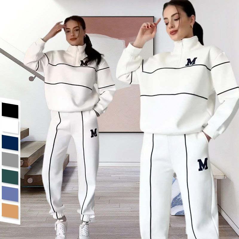 Women wearing white streetwear tracksuit with black piping, loose fit, half-zip top, elastic cuffs