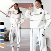 Women wearing white streetwear tracksuit with black piping, loose fit, half-zip top, elastic cuffs