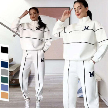 Women wearing white streetwear tracksuit with black piping, loose fit, half-zip top, elastic cuffs