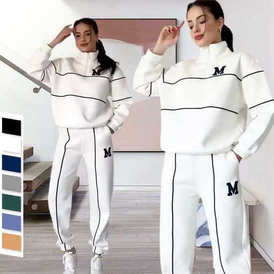 Women wearing white streetwear tracksuit with black piping, loose fit, half-zip top, elastic cuffs