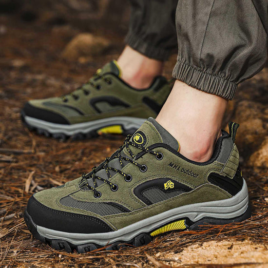 Olive green outdoor sneakers with black mesh panels, rugged sole, and lace-up closure on forest floor
