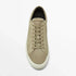 Beige suede low-top sneaker with lace-up closure and white rubber sole, minimalist style