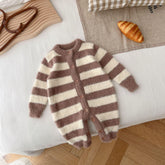Brown and cream striped fuzzy knit baby romper with front buttons, laid flat on a bed