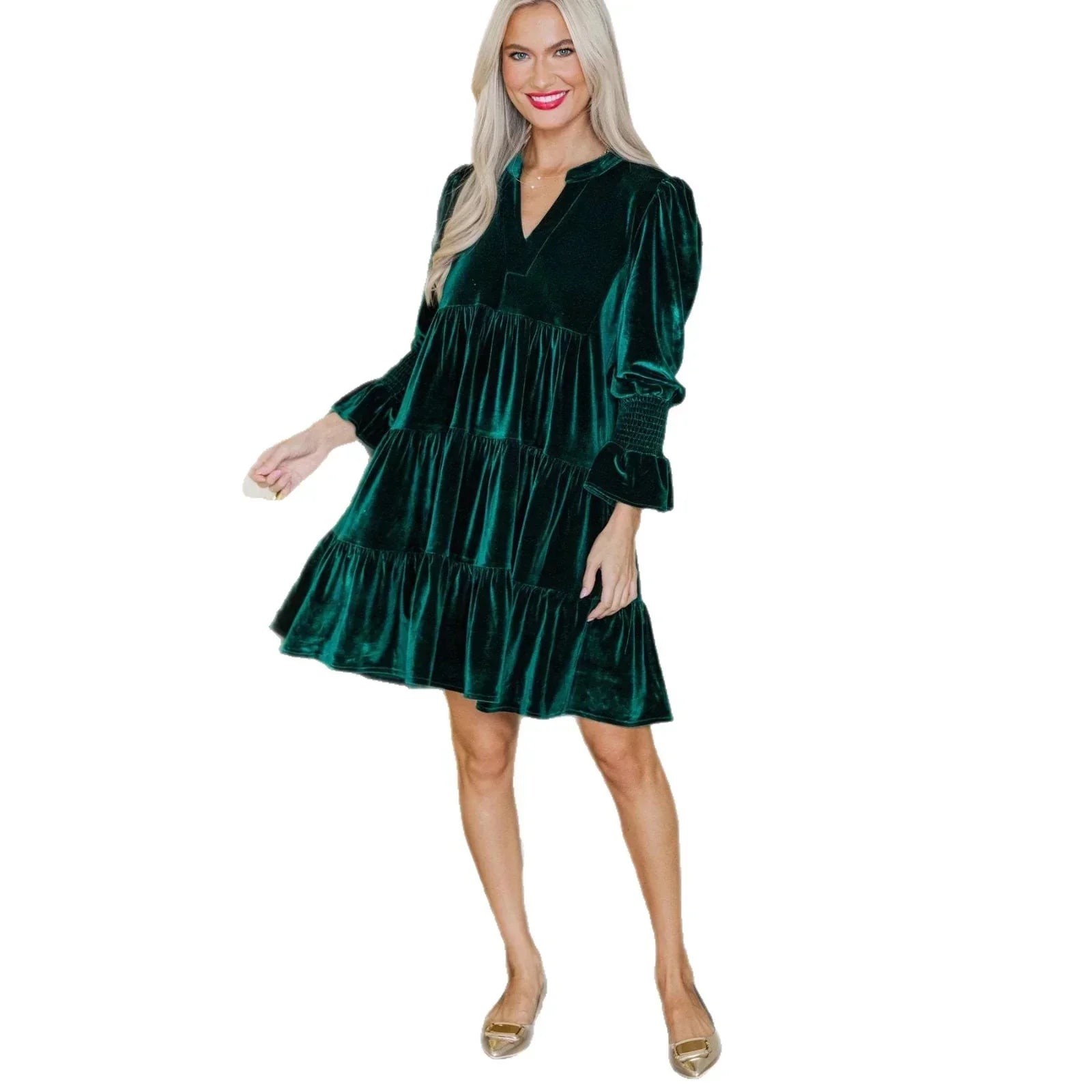 Woman wearing dark green velvet tiered mini dress with long sleeves and relaxed fit