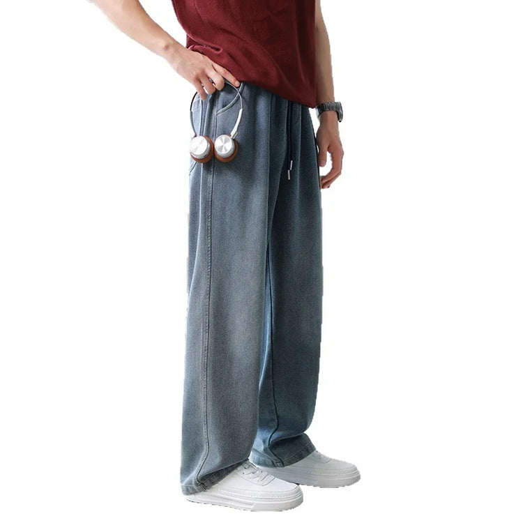 Loose fit light blue denim jeans, wide leg, styled with casual sneakers and a burgundy shirt