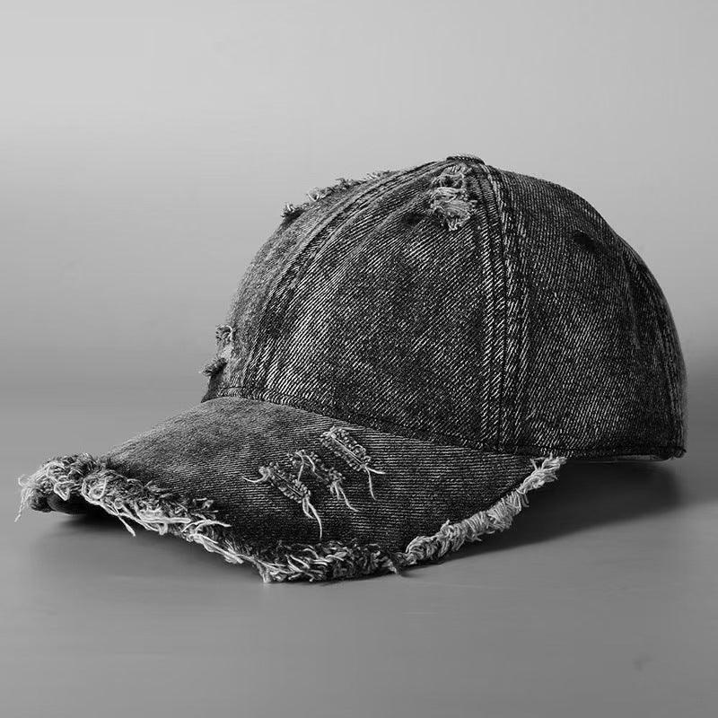 Washed black denim distressed baseball cap with frayed edges and relaxed fit