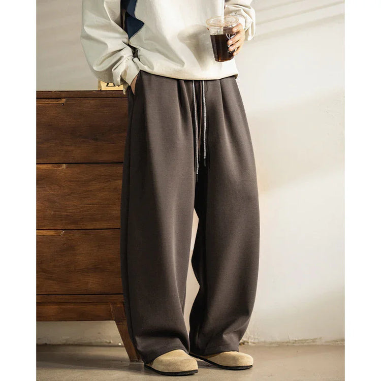 Loose fit dark brown sweatpants with drawstring waist, casual streetwear style