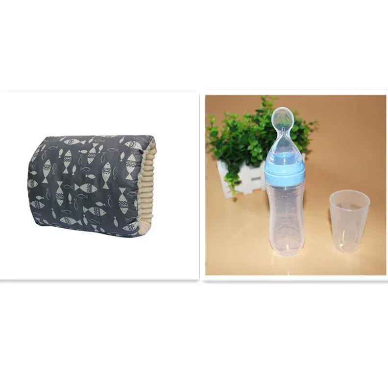 Gray patterned cushion with fish design next to a clear baby bottle with blue cap and cup