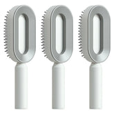 Three modern grey and white oval hair brushes with ergonomic handles and plastic bristles.