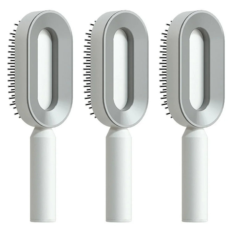 Three modern grey and white oval hair brushes with ergonomic handles and plastic bristles.